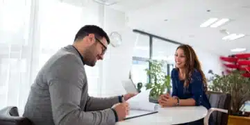Entrevista de emprego com candidato e recrutador em escritório moderno."