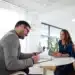 Entrevista de emprego com candidato e recrutador em escritório moderno."