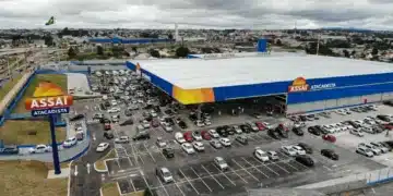 Fachada do Assaí Atacadista com estacionamento lotado e pessoas entrando na loja.