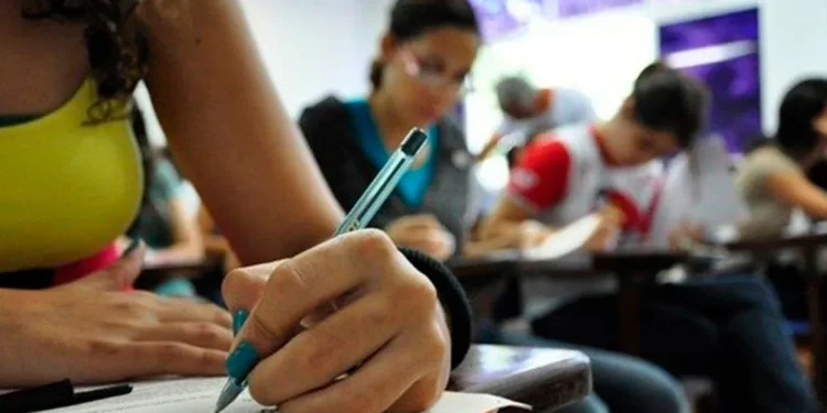 Estudantes concentrados realizando uma prova em sala de aula.