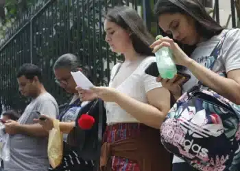 Estudantes aguardam na fila para prova de vestibular.