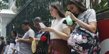 Estudantes aguardam na fila para prova de vestibular.