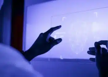 Pessoa interagindo com uma interface holográfica de reconhecimento facial em um ambiente futurista.