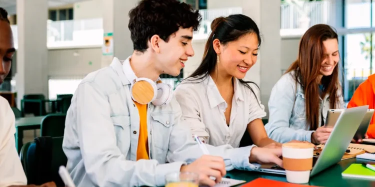 Grupo de estudantes estudando juntos em um ambiente acadêmico moderno.