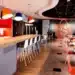 Ambiente moderno de restaurante com mesas e balcão.