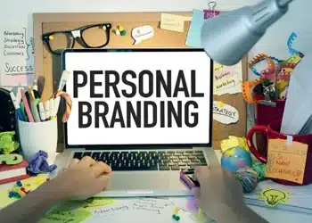 Mesa de trabalho criativa com anotações sobre personal branding e laptop exibindo a frase "Personal Branding