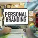 Mesa de trabalho criativa com anotações sobre personal branding e laptop exibindo a frase "Personal Branding