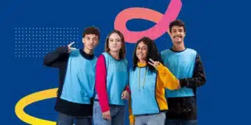Grupo de jovens sorrindo, vestindo coletes azuis, posando para a foto.