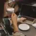 Mulher tomando café enquanto trabalha no laptop em uma cafeteria.
