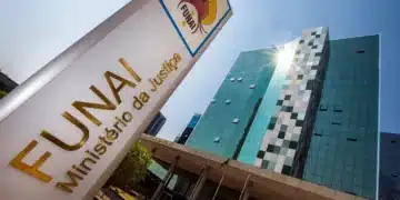 Fachada do edifício da FUNAI com placa institucional e céu azul ao fundo.