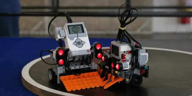  Robôs LEGO EV3 com luzes vermelhas e braços mecânicos, prontos para uma competição.