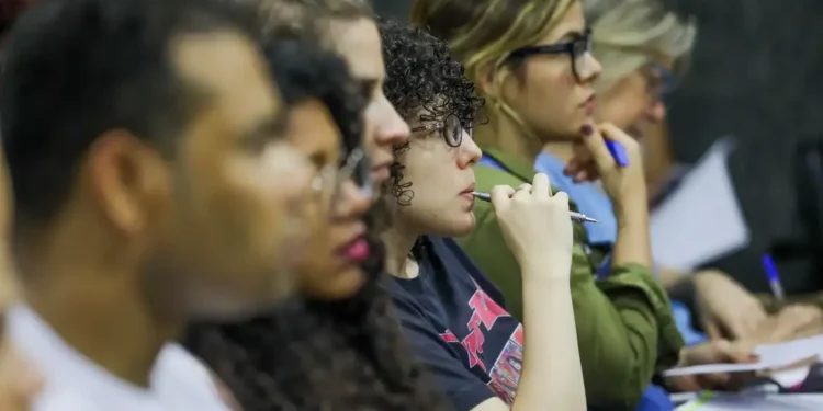 Grupo de estudantes ouvindo atentamente durante uma palestra ou aula.