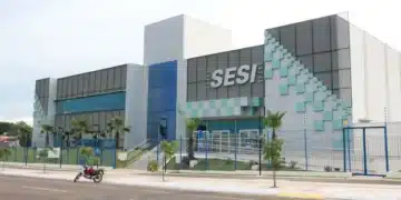 Fachada moderna de uma unidade do SESI com arquitetura contemporânea e área verde ao redor.