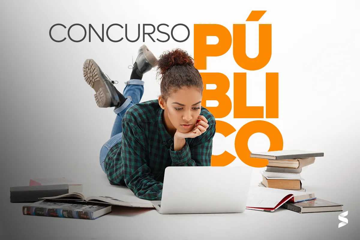 Jovem estudando para concurso público, deitada no chão com livros ao redor e usando um laptop, representando preparação para o processo seletivo do SAMU.