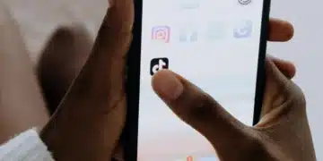 Pessoa segurando um smartphone com o aplicativo TikTok aberto, simbolizando o processo de ganhar dinheiro na plataforma.