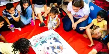 Crianças reunidas em círculo em uma atividade de leitura interativa com um grande livro ilustrado.