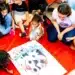 Crianças reunidas em círculo em uma atividade de leitura interativa com um grande livro ilustrado.