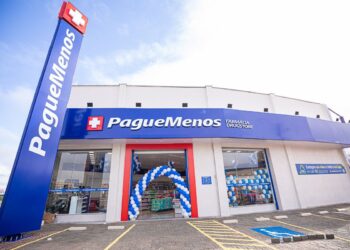 Fachada de uma unidade da Farmácia Pague Menos com decoração azul e branca.