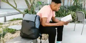Estudante lendo livro ao ar livre, simbolizando o acesso à educação com a nova bolsa de R$ 200 do governo.