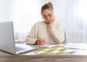 Mulher estudando com anotações em post-its, representando a estratégia dos 3 Rs para melhorar o aprendizado.