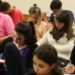 Jovens e adultos participando de uma sala de aula no contexto da EJA (Educação de Jovens e Adultos), com alunos focados em suas atividades.