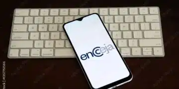 Imagem de um smartphone com o logo do Encceja 2025 exibido na tela, sobre uma mesa com um teclado branco ao fundo.