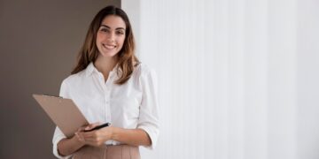 Mulher de negócios elegante, sorrindo enquanto segura uma prancheta com espaço para anotações.