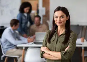 Mulher sorrindo e olhando para a câmera, simbolizando confiança e sucesso no ambiente profissional, refletindo sobre as escolhas de modalidades de trabalho.