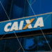 Fachada de uma agência da Caixa Econômica Federal com logotipo destacado em letras brancas sobre fundo azul.