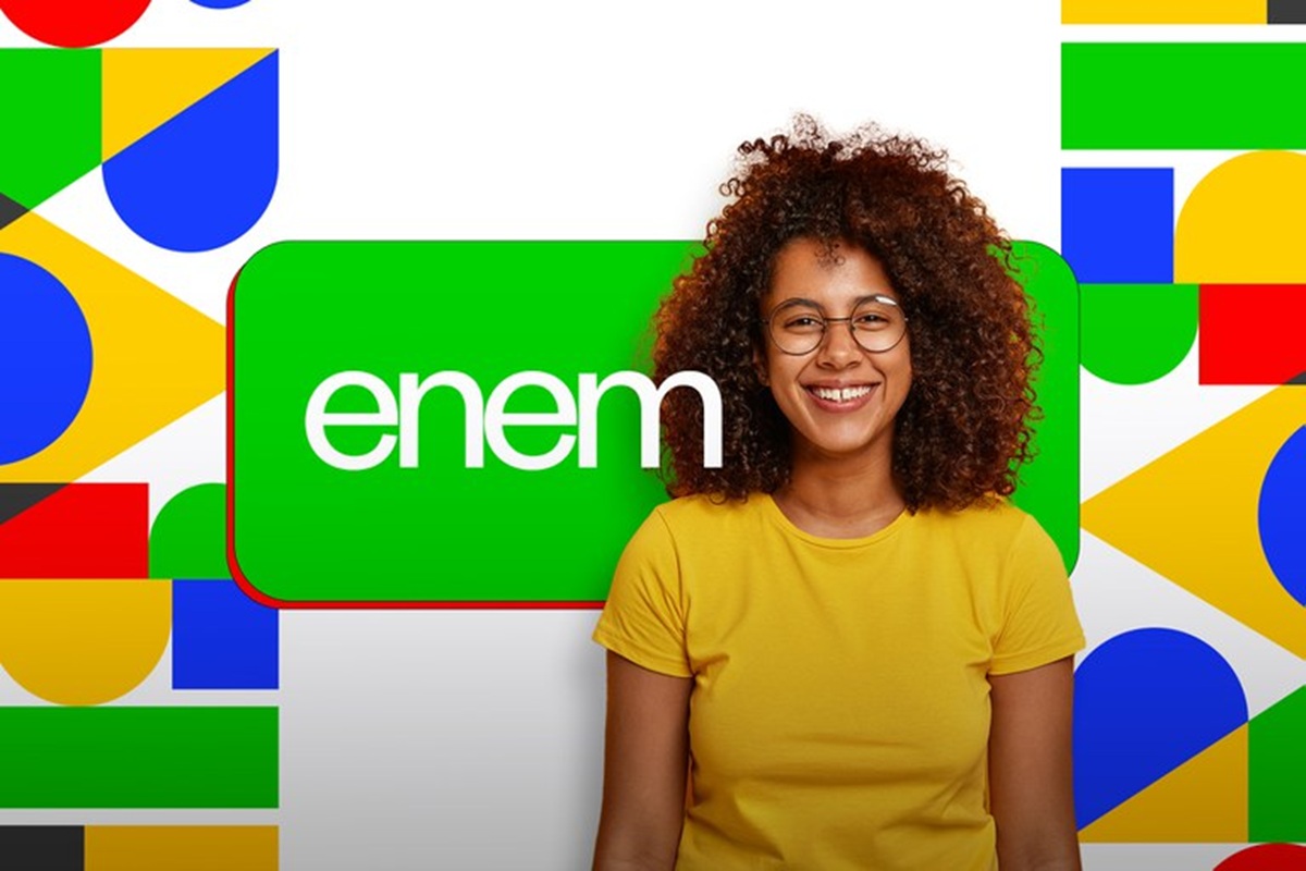 Jovem sorridente com óculos e cabelo cacheado em fundo colorido com logo do Enem