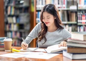 Jovem estudante concentrada em anotações durante curso gratuito de qualificação