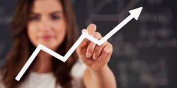 Mulher desenhando um gráfico de crescimento, simbolizando o progresso e os hábitos das pessoas bem-sucedidas.