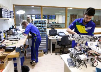 Estudantes de cursos técnicos do SENAI trabalhando em laboratório de robótica e eletrônica.