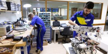 Estudantes de cursos técnicos do SENAI trabalhando em laboratório de robótica e eletrônica.