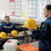 Técnica apresenta capacete de segurança durante aula sobre normas de segurança do trabalho