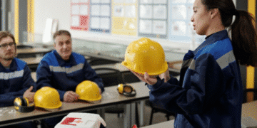 Instrutora apresenta capacete de segurança em sala de aula de curso técnico