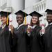 Jovens formandos comemorando com diplomas na mão após conclusão da graduação