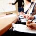 Participantes de um curso técnico em treinamento, concentrados e anotando informações em uma sala de aula.