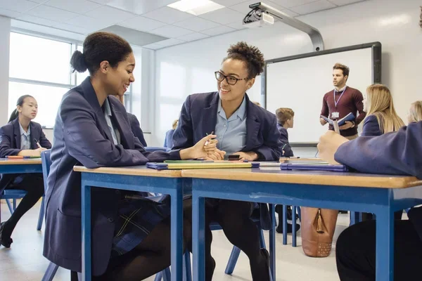Estudantes colaborando em uma sala de aula, em uma atividade de aprendizado em grupo