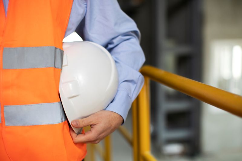 Profissional da área de segurança do trabalho segurando capacete branco