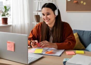 Estudante sorrindo enquanto faz curso técnico online no computador