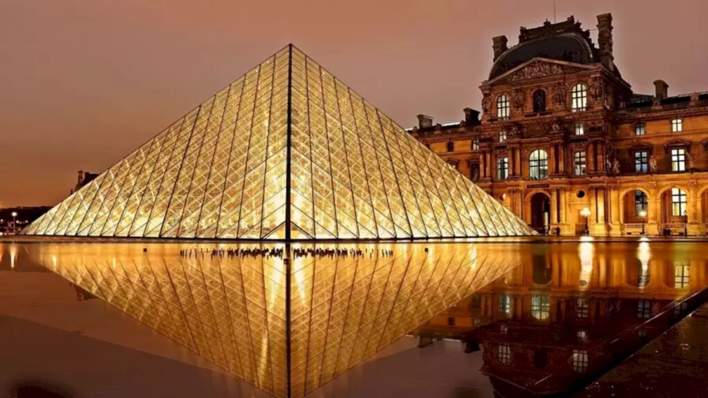 Teste de QI com uma imagem noturna da pirâmide de vidro do Museu do Louvre, refletindo no espelho d'água.