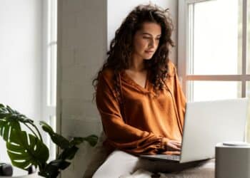 Mulher usando notebook para trabalhar pela internet