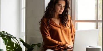 Mulher usando notebook para trabalhar pela internet