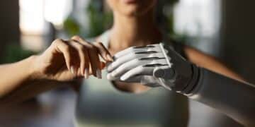 Mulher interagindo com uma prótese de mão, simbolizando o impacto da IA nas profissões da saúde e tecnologia assistiva.