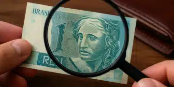 Pessoa examinando uma cédula rara de 1 real com uma lupa