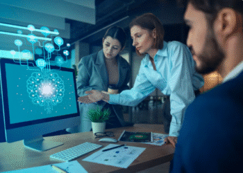 Profissionais analisando dados em tela com inteligência artificial no ambiente de trabalho.