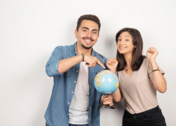 Estudantes felizes segurando um globo terrestre simbolizando intercâmbio internacional