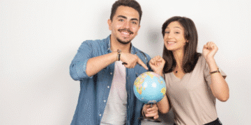 Estudantes felizes segurando um globo terrestre simbolizando intercâmbio internacional