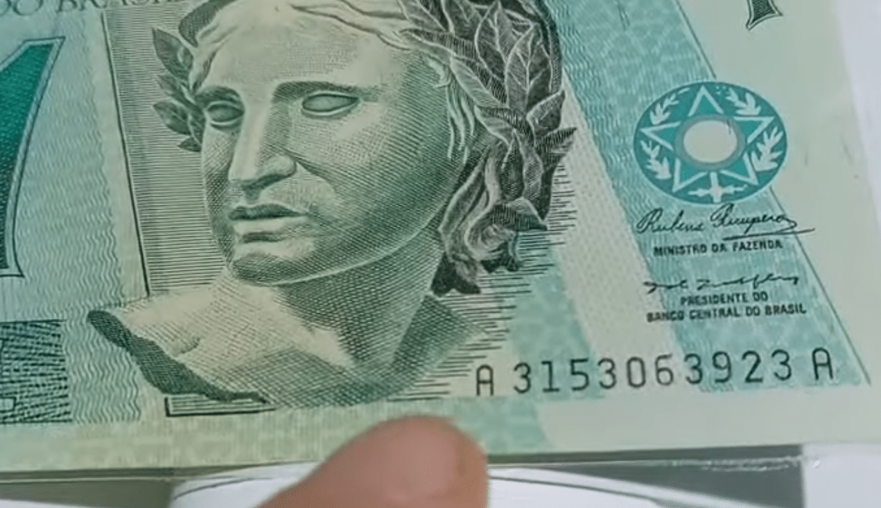 Série de cédula de 1 real sendo destacada com o dedo